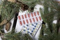 The blisters with pills. Different colors. Spruce and pine branches with cones. On a wooden box Royalty Free Stock Photo