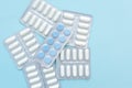 Blisters of white and blue pills on blue background, top view. Different pharmaceuticals, tablets, medicine capsules. Royalty Free Stock Photo