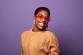 Blithesome african woman in sunglasses chilling during photoshoot. Indoor shot of adorable black girl in pink glasses