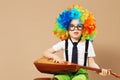 Blithesome children. Happy clown boy in large neon colored wig p