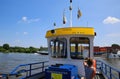 View on drivers cabin of small passenger and bicycle ferry voet- en fietsveer on river maas, container ship background in summer