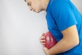 Bloating and flatulence concept. The man holds a red balloon near the abdomen, which symbolizes gas problems. Intestinal tract and