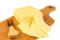 Block of cheese and slices on cutting board with knife Royalty Free Stock Photo