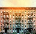 Block of classic old brick apartment buildings with windows and fire escapes in New York City Royalty Free Stock Photo