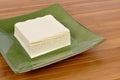 Asian food : Block of fresh Tofu on green plate, wood background Royalty Free Stock Photo