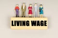 On the block with the inscription - Living Wage, there are miniature figures of people.