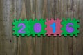 Block letters and numbers 2016 with wood background Royalty Free Stock Photo