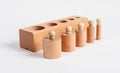 Block and Montessori knobbed cylinders placed in correct order from thicker to thinner. Wooden childish game for