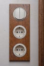 A block of two sockets and a two-position switch in retro style. Handmade decorative electric socket made of oak. Creative