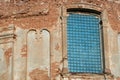 block window in the wall of an old brick building in the antique style with columns and arched arches. A ruined Church or castle.