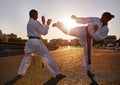 Blocked. Two sportspeople facing off and practicing their karate while wearing gi.