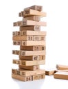 Blocks of game jenga on white background. Vertical tower whole and in game. Wooden blocks in stack with figures digit on Royalty Free Stock Photo