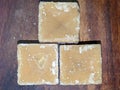 Blocks of Indian jaggery isolated on Wooden background