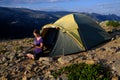 Blode hair woman relaxing outside of a tent using her phone Royalty Free Stock Photo