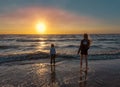 Bloemendaal, the Netherlands, 8-8-2018. Boy and girl playing at the beach with their feet in the waves of the rising tide, while t Royalty Free Stock Photo