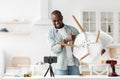 Blog about furniture repair and assembly. Happy african american man showing finished chair to smartphone camera Royalty Free Stock Photo