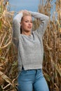 Blog style fashion photo of cute blond woman on corn field in late autumn
