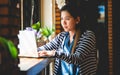 Blogger Asian Women`s writers are using laptops at the coffee shop to write, share stories or travel reviews to her social media