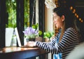 Blogger Asian Women`s writers are using laptops at the coffee shop to write, share stories or travel reviews to her social media