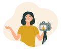 The blogger girl smiles and gestures in front of the camera, recording the video, photo. Vector illustration in flat style Royalty Free Stock Photo