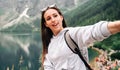 Blogger girl. Young female travel photographer with smartphone on summer mountain rock nature background. Freedom Royalty Free Stock Photo