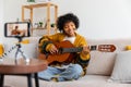 Blogger guitarist. Happy african american girl blogger playing guitar singing song recording vlog. Social media Royalty Free Stock Photo