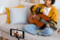 Blogger guitarist. Happy african american girl blogger playing guitar singing song recording vlog. Social media Royalty Free Stock Photo