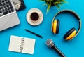 Blogger, journalist or musician office desk with computer keyboard, notebook, microphone and headphones on blue