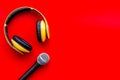 Blogger, journalist or musician office desk with microphone and headphones on red background top view copyspace