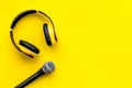 Blogger, journalist or musician office desk with microphone and headphones on yellow background top view copyspace