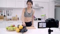 Blogger sporty Asian woman using camera recording how to make grape juice video for her subscriber, female use organic fruit.
