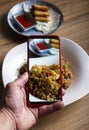 Blogger takes a picture of the dishes on the table of the oriental restaurant