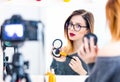 blogger woman applying cosmetics at camera