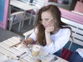 Blogger woman at a cafe. Coffeebreak in a summer warm day