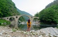 Blogger woman enjoying roman structure in Bulgaria. Devil Bridge historical monument. Fashion Girl traveler with hat on a valley. Royalty Free Stock Photo