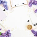 Blogger workspace with clipboard, dairy, envelope, lilac flowers and accessories on white background. Flat lay, top view. Copy spa Royalty Free Stock Photo