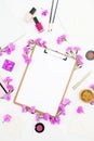 Blogger workspace with clipboard, notebook, pink flowers and accessories on white background. Flat lay, top view Royalty Free Stock Photo