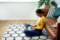 Blogging is my passion. an attractive young woman sitting crosslegged on the floor and using her laptop at home.