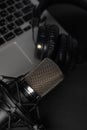 Blogging, podcasts, streams and broadcast, background. Black studio microphone on a laptop on a black background Royalty Free Stock Photo