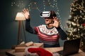 blogging, technology and people - happy guy blogger in Santa hat with ring light and smartphone doing VR glasses test