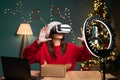 blogging, technology and people - happy smiling girl blogger in santa hat with ring light and smartphone doing VR