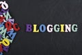 BLOGGING word on black board background composed from colorful abc alphabet block wooden letters, copy space for ad text