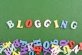 BLOGGING word on green background composed from colorful abc alphabet block wooden letters, copy space for ad text. Learning