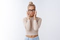 Blond attractive businesswoman in glasses feeling pressured and drained massaging temples sighing irritated looking away