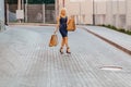 Blond attractive girl in a hat after shopping in the rays of the summer sun Royalty Free Stock Photo