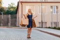 Blond attractive girl in a hat after shopping in the rays of the summer sun Royalty Free Stock Photo