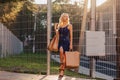 Blond attractive girl in a hat after shopping in the rays of the summer sun Royalty Free Stock Photo