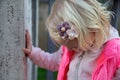 Blond baby girl dressed in pink with hairpins with flowers. Accessories and hairdo for children. Looking down. Walking Royalty Free Stock Photo
