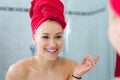 Blond in a bath with a red towel on the head