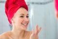 Blond in a bath with a red towel on the head